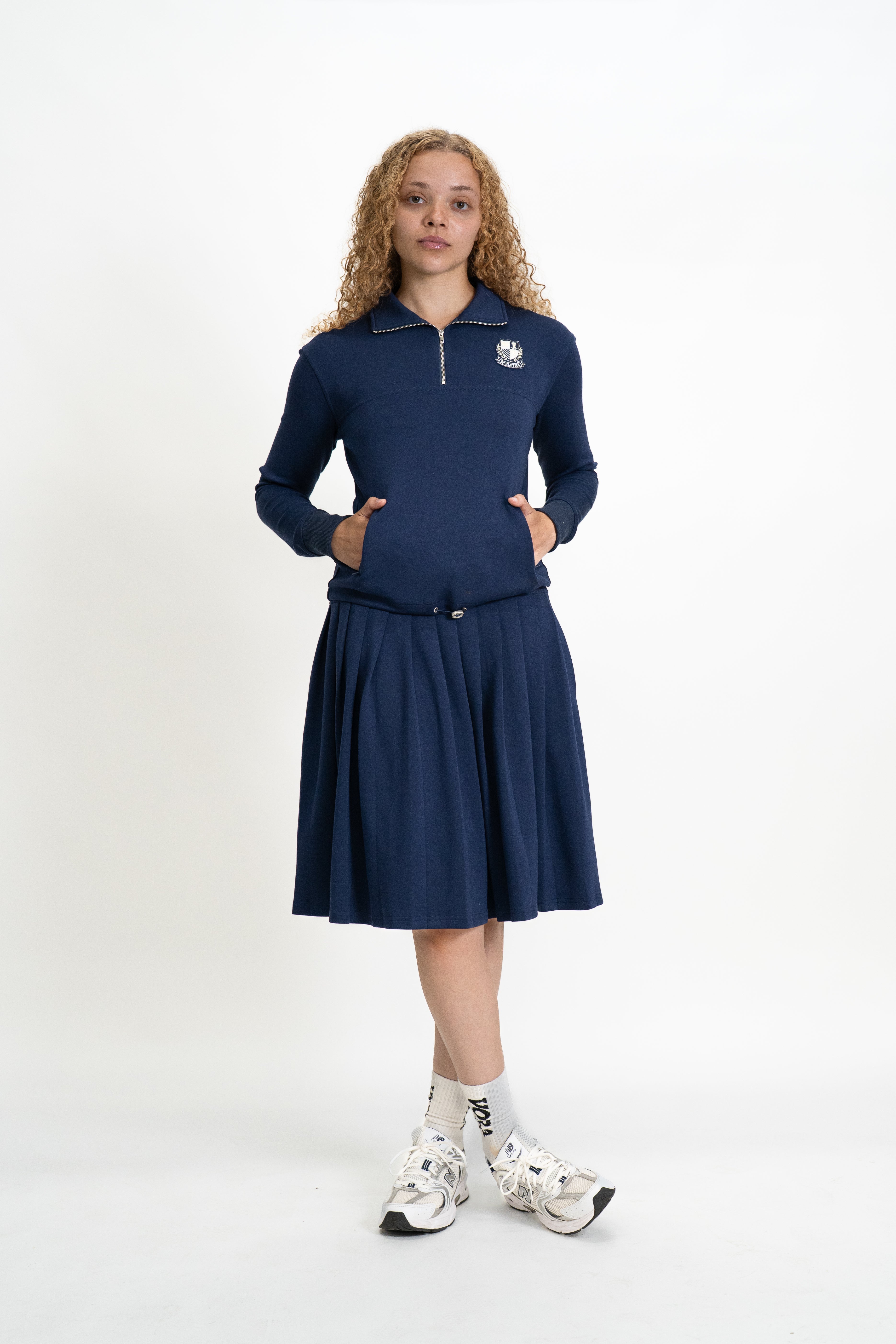 Woman wearing a navy blue dress with a logo on a white background